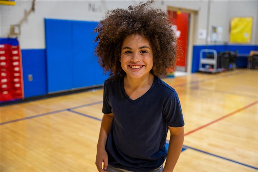 A boy wearing a black shirt smiles